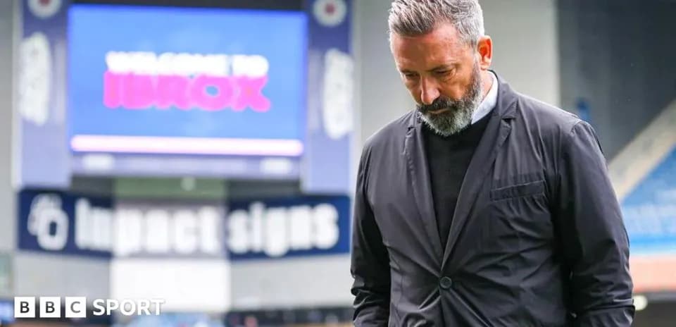 Manager walking with head down at Ibrox stadium