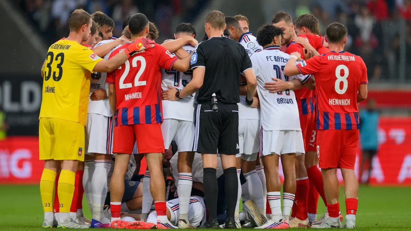 Players from both teams gathered around a fallen player