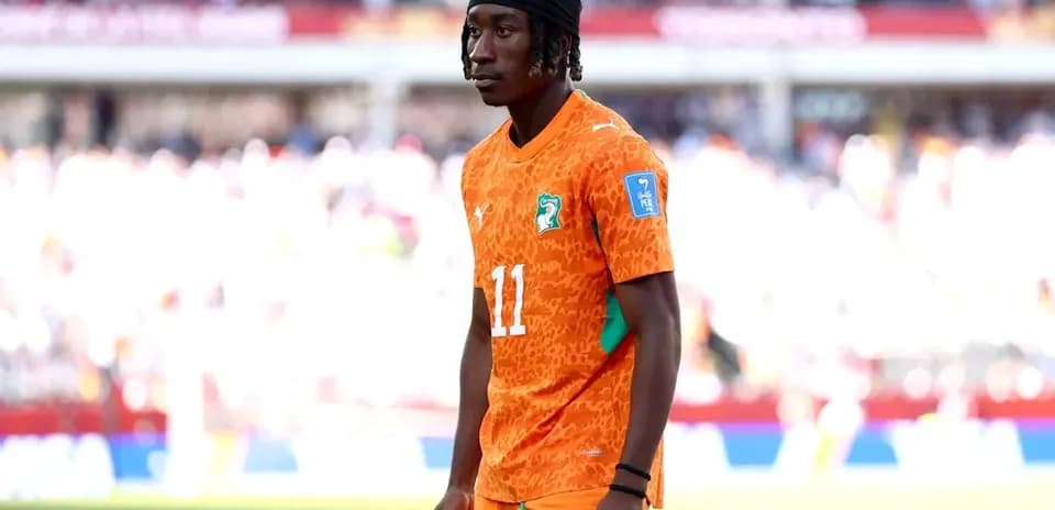 Player in orange jersey standing on the pitch