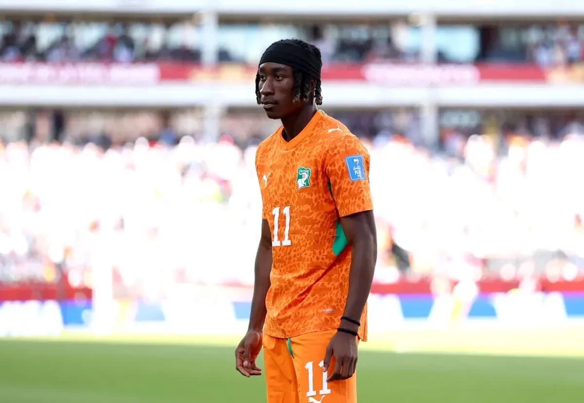 Player in orange jersey standing on the pitch