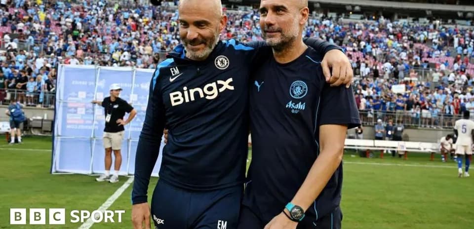 Two football coaches embracing on the pitch