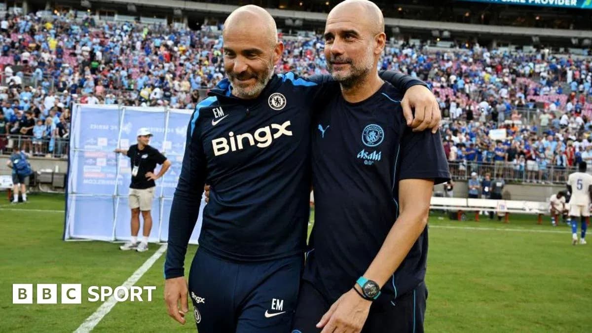 Two football coaches embracing on the pitch