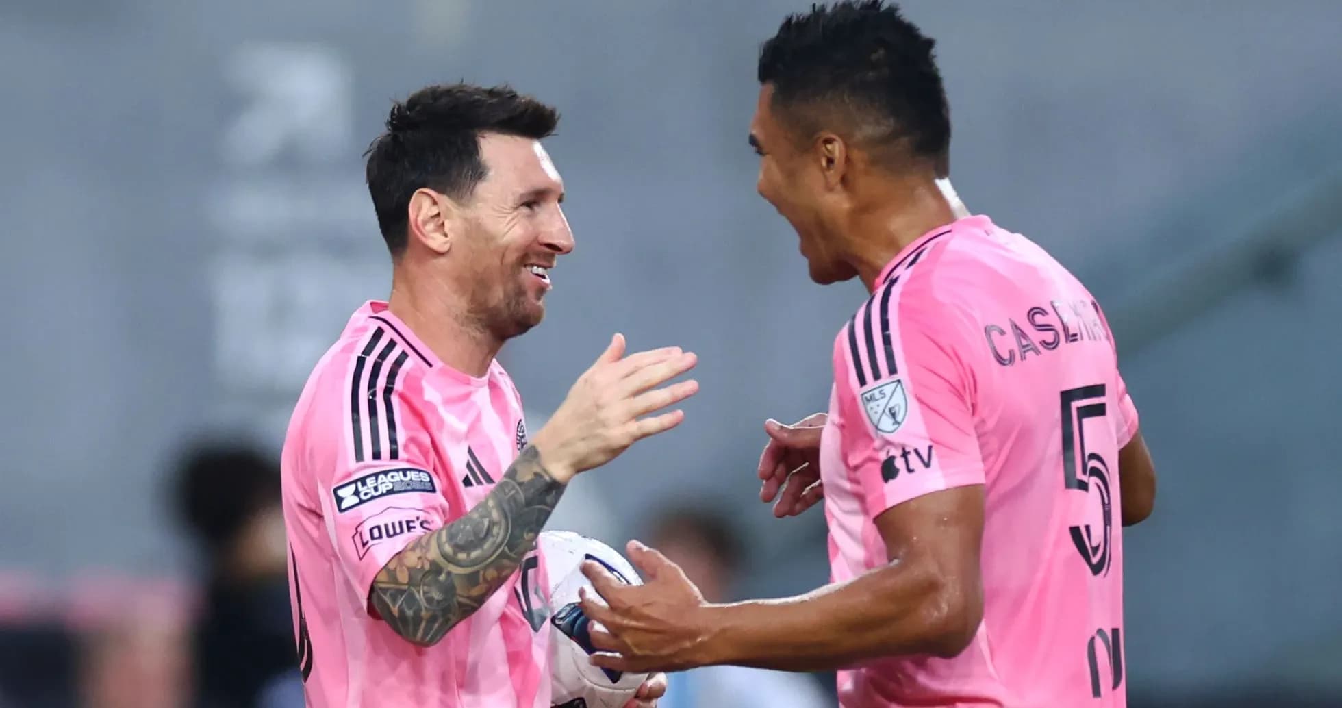 Players celebrating on the field in pink jerseys