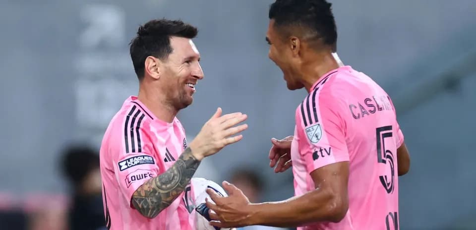 Players celebrating on the field in pink jerseys