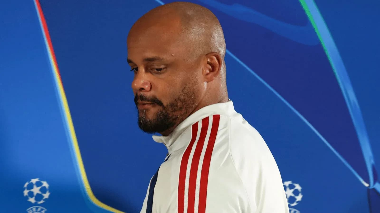Manager walking past Champions League backdrop