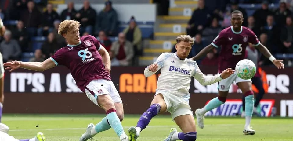 Burnley player tackling Aston Villa player during match