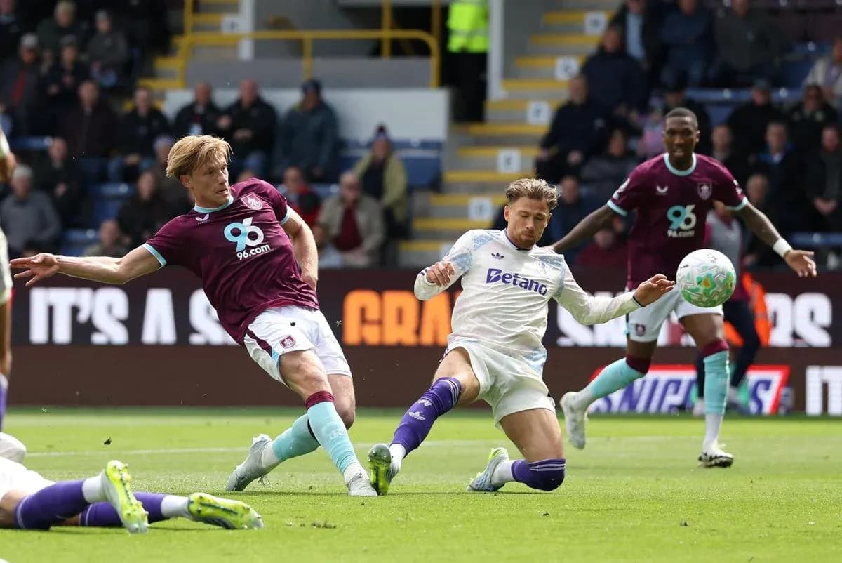Burnley player tackling Aston Villa player during match