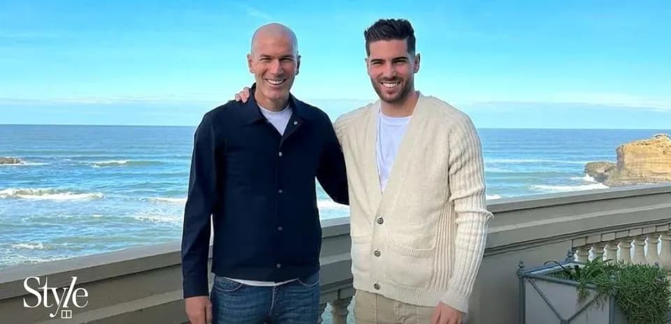 Two men posing by the ocean with blue sky