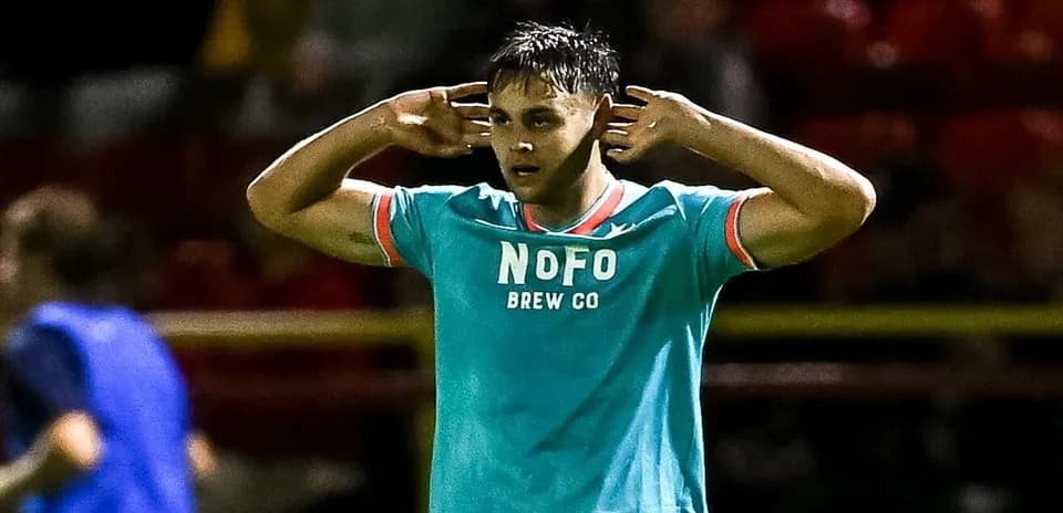 Player gesturing with hands to ears on field