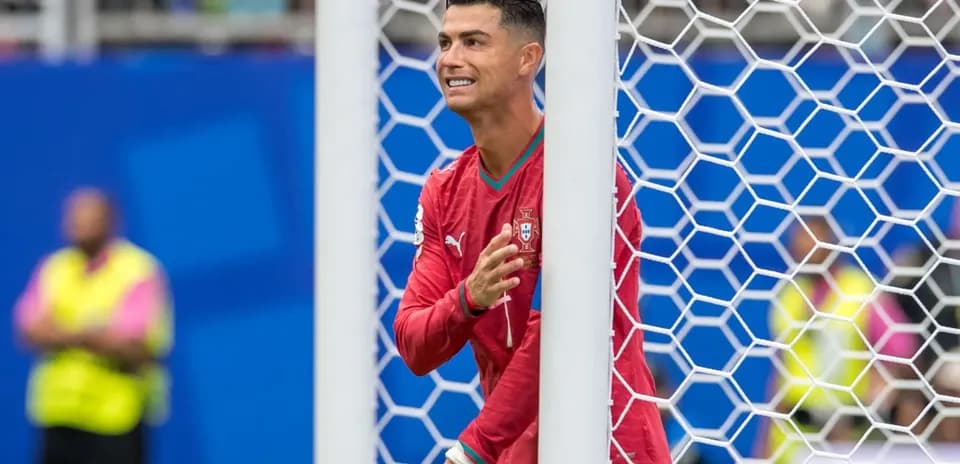 Player in red jersey celebrating near goalpost