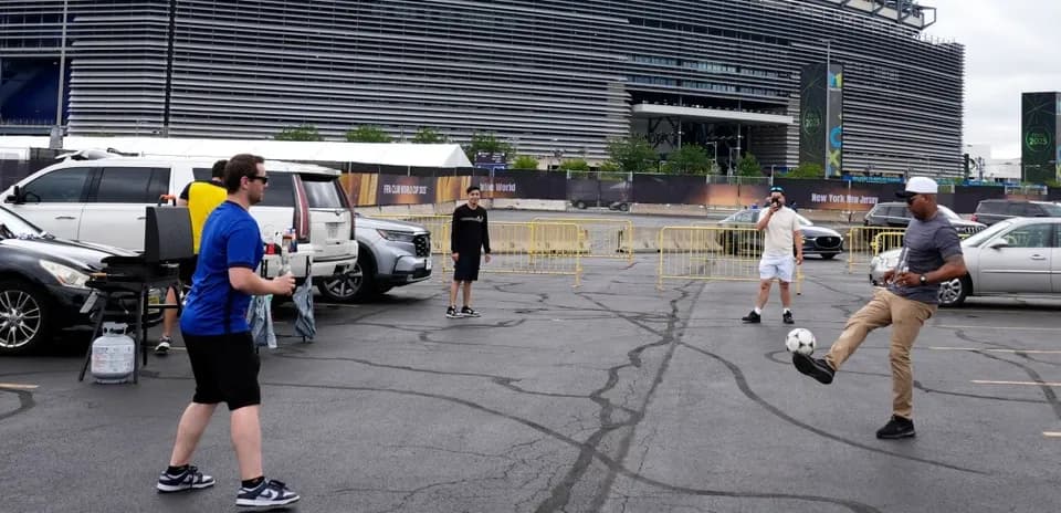 Group playing soccer in parking lot near stadium