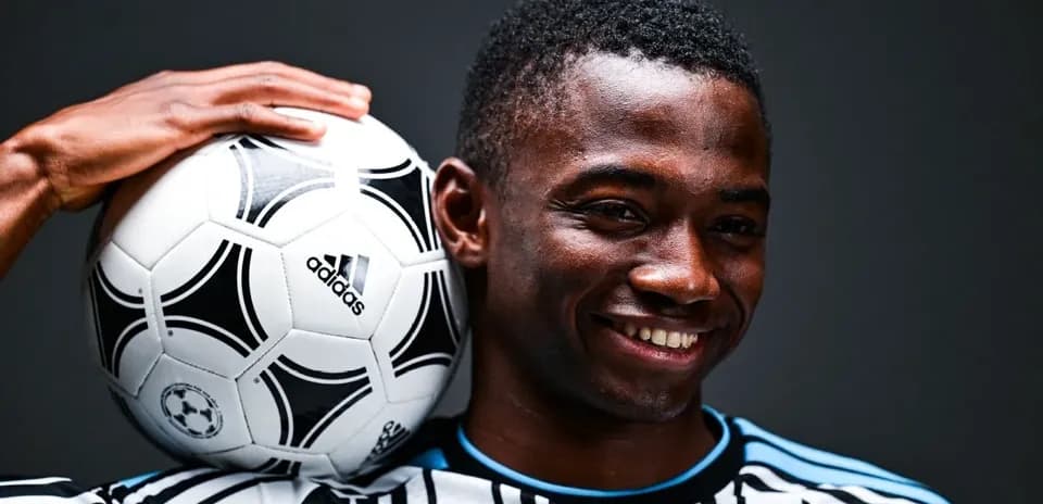 Player holding a soccer ball on shoulder