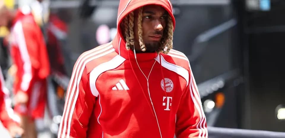 Player arriving at stadium in red team tracksuit