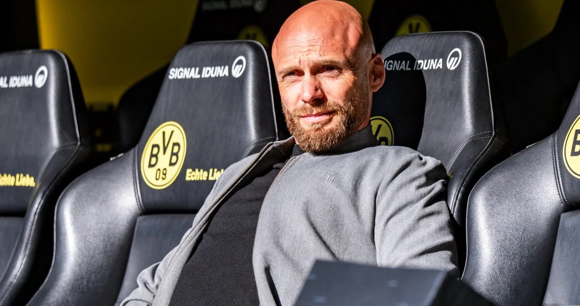 Coach sitting on team bench at stadium