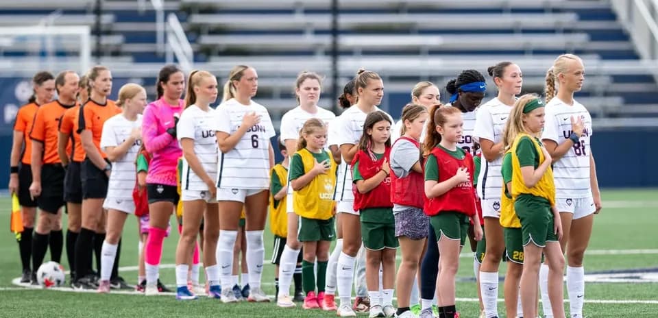 UConn soccer team and youth players during national anthem