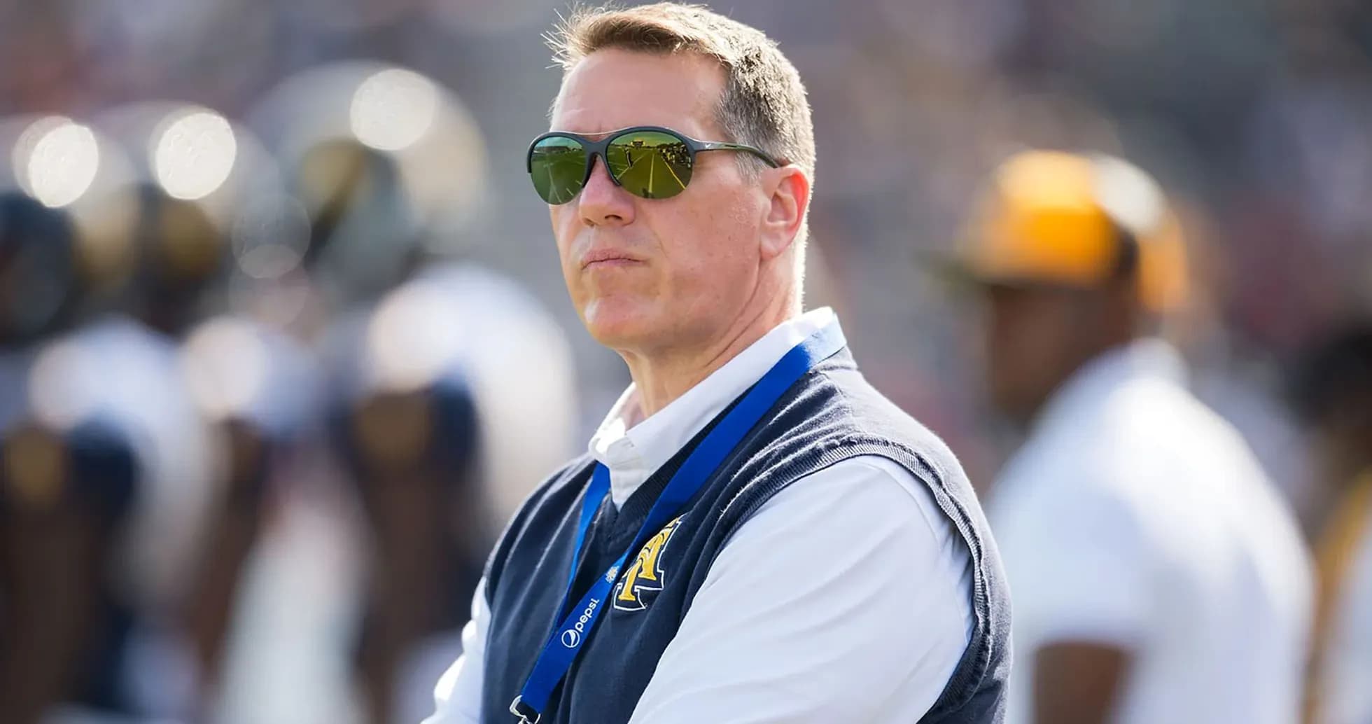 Man in sunglasses observing a football game
