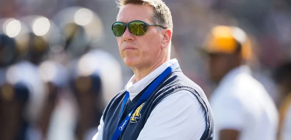 Man in sunglasses observing a football game