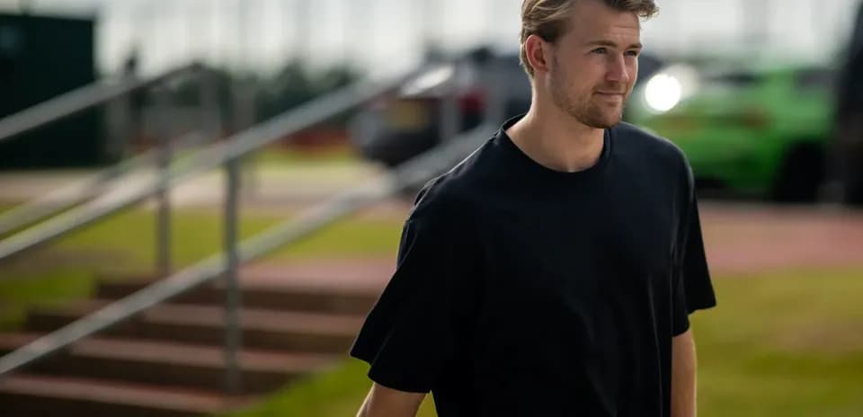 Player walking on training ground towards facility