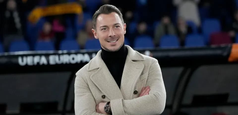 Person smiling with arms crossed at a match