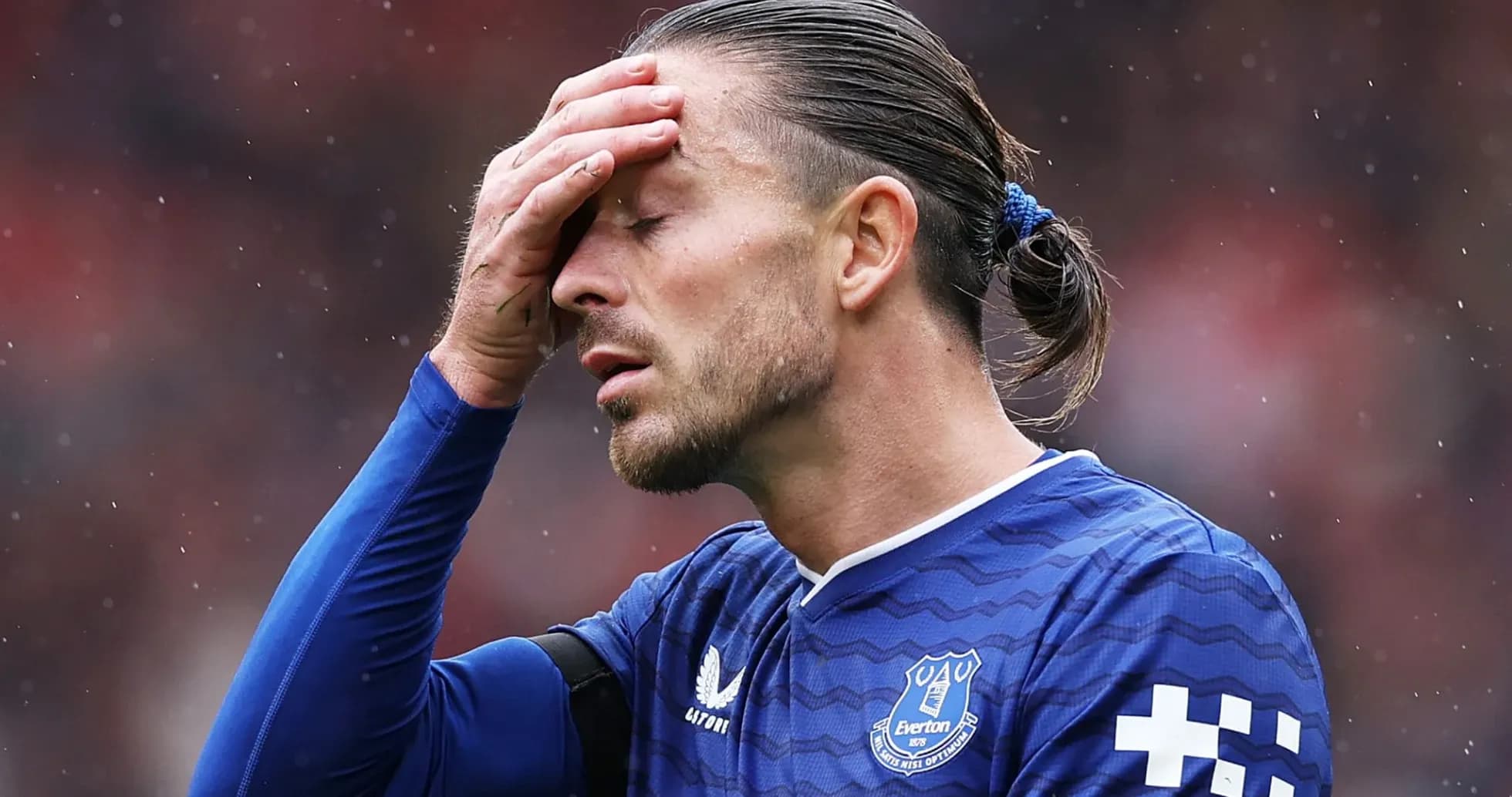 Player holding forehead during match in blue jersey