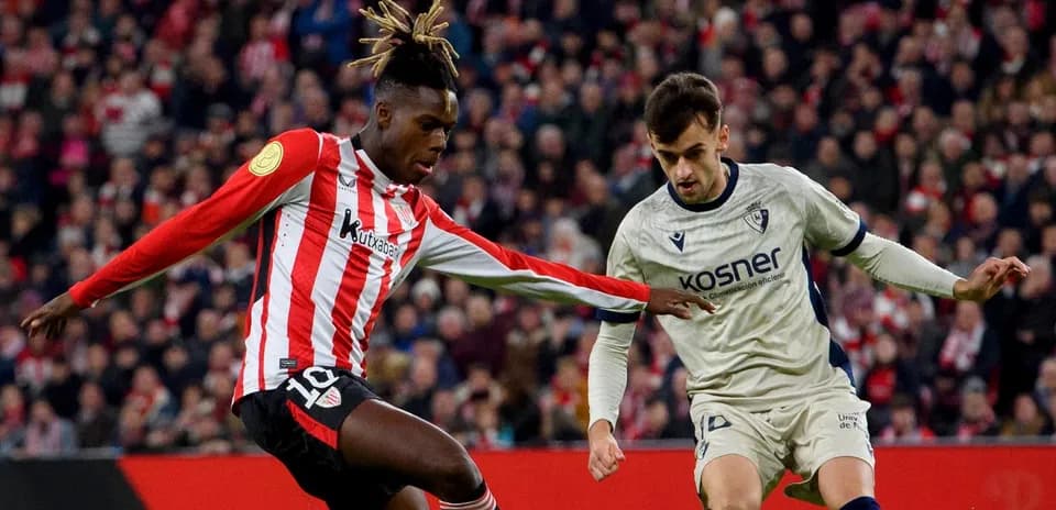 Athletic Club player challenging Osasuna opponent