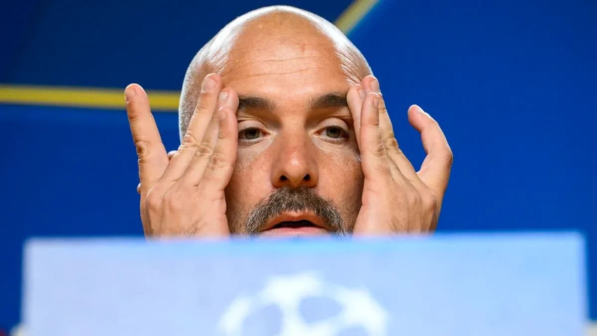 Manager at press conference with hands on face