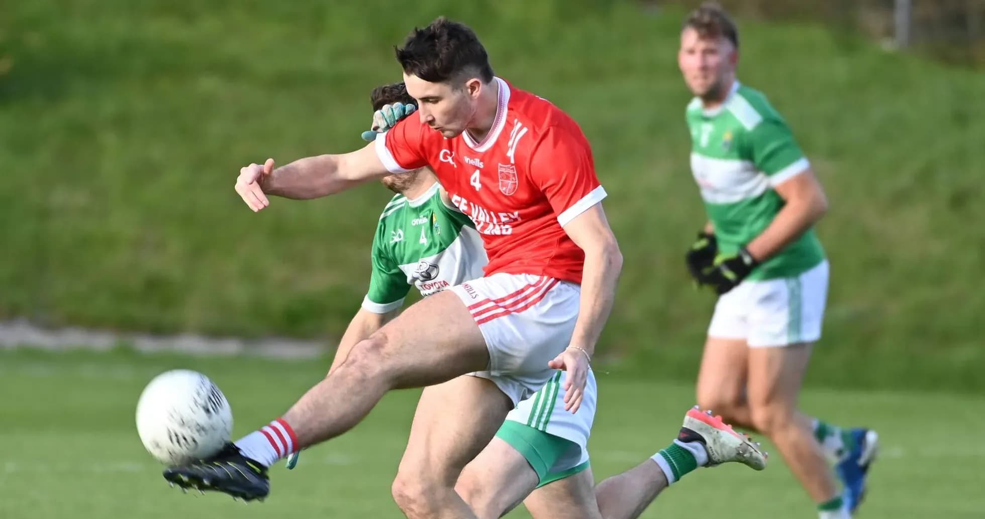 Player kicking ball during Gaelic football match