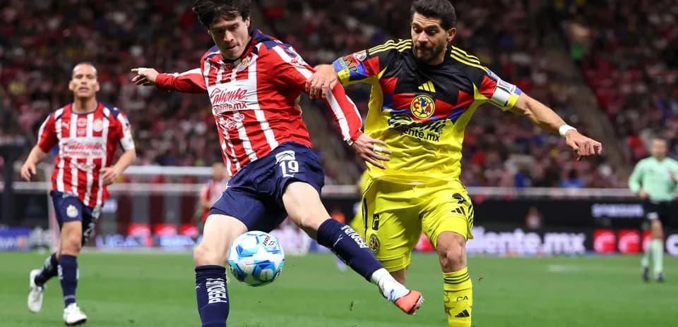 Club America player challenges Chivas player for the ball