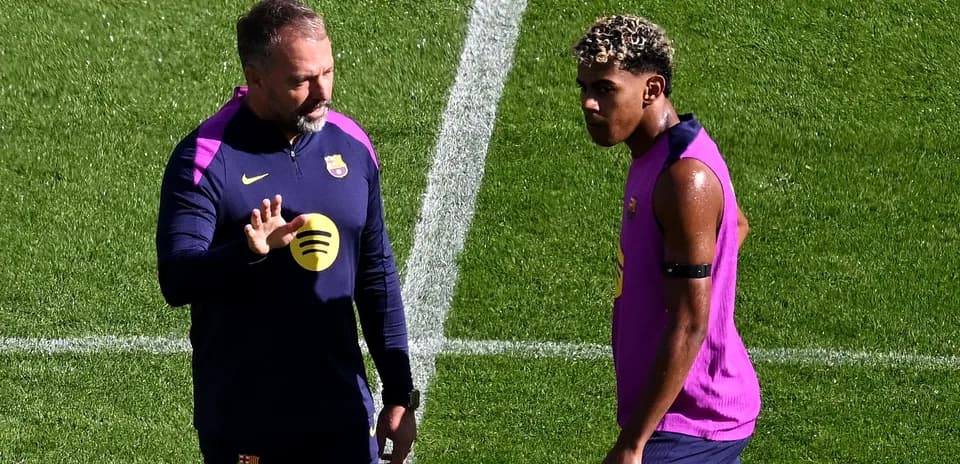 Coach instructing player during Barcelona training session