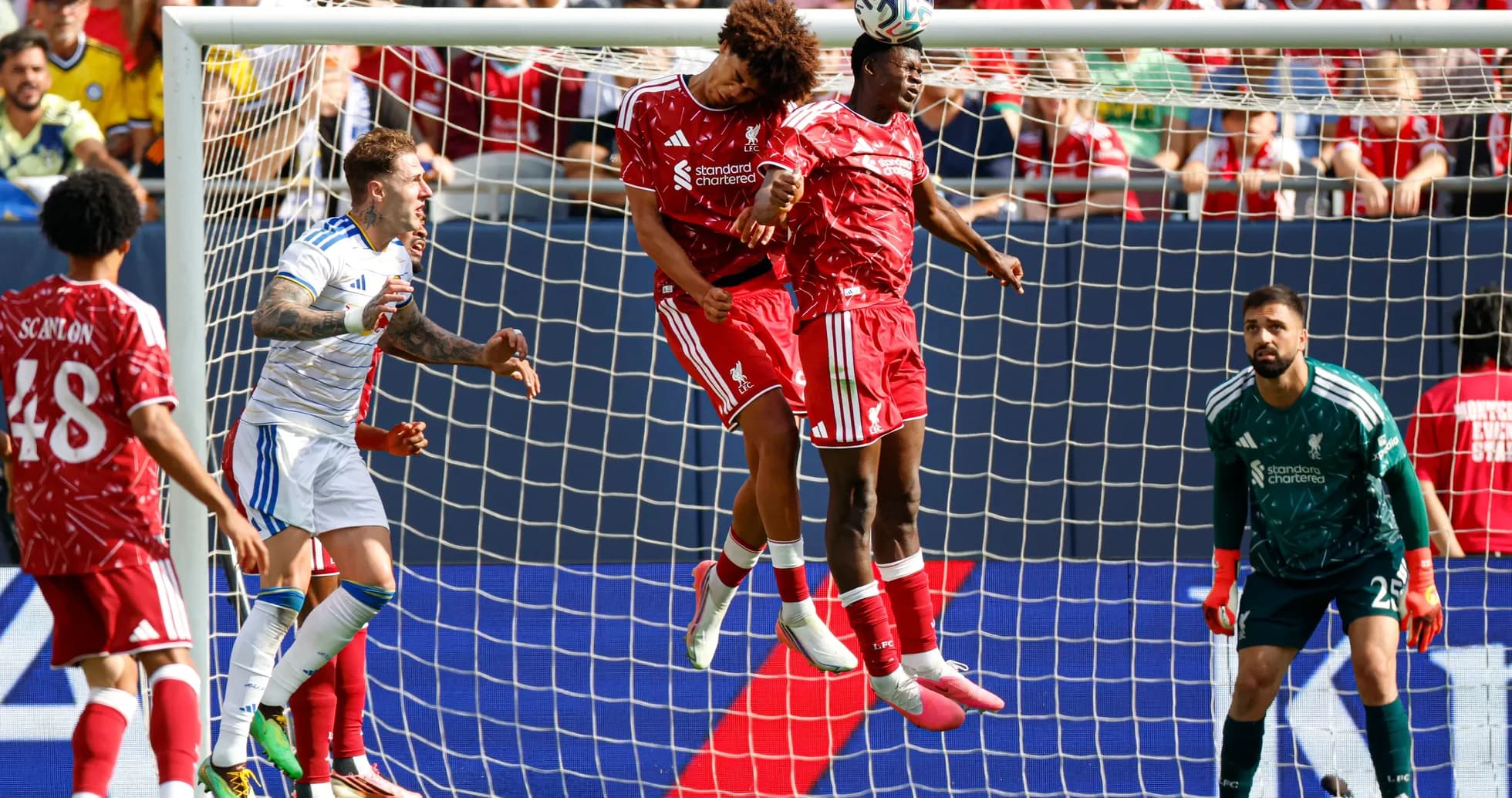 Two players jumping for header in goal area