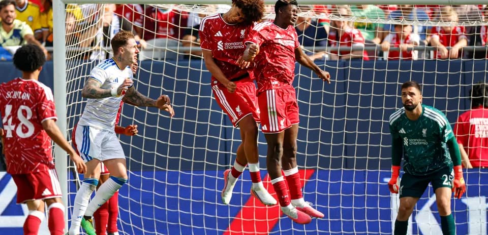 Two players jumping for header in goal area