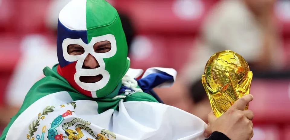 Fan in mask holding FIFA World Cup trophy