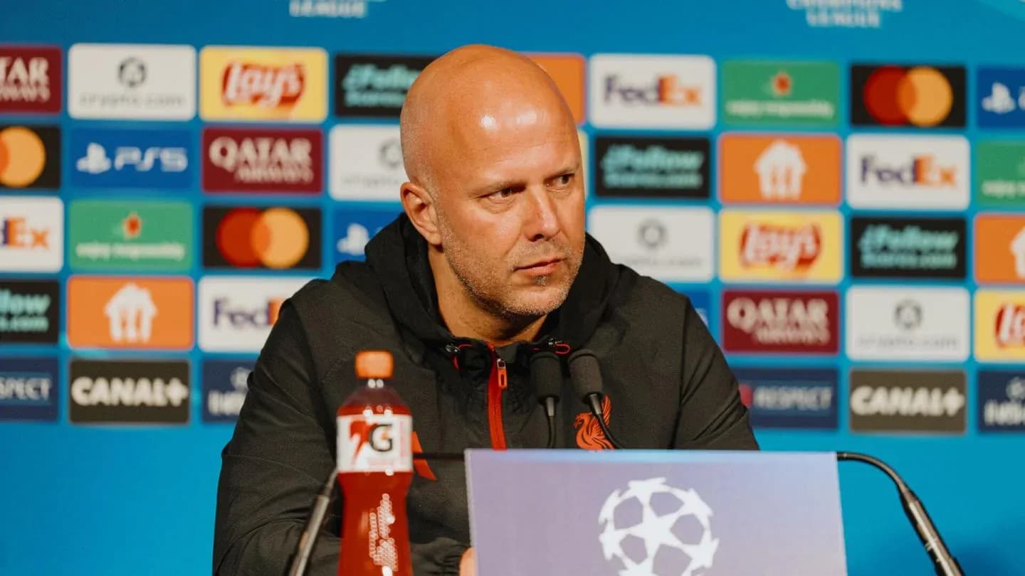 Manager speaking at press conference with sponsor backdrop