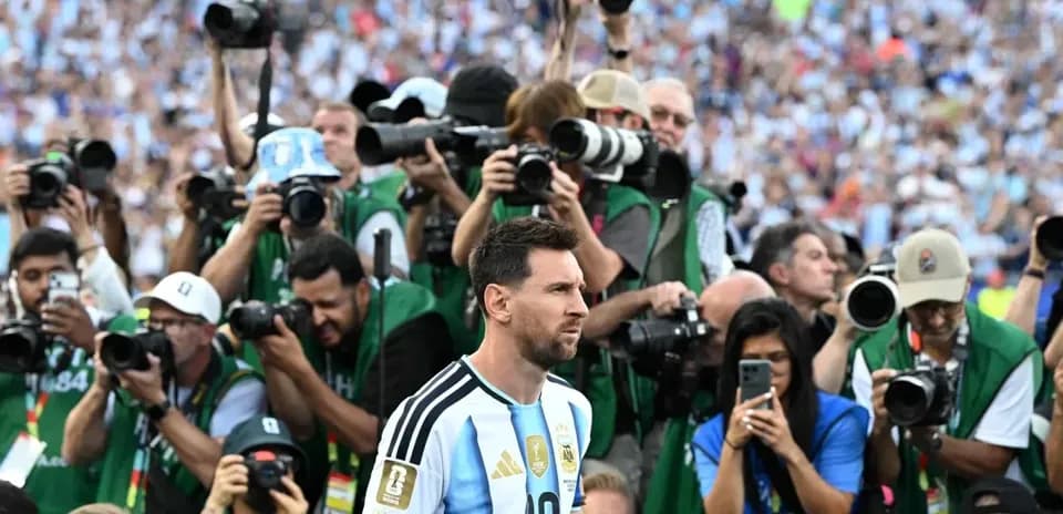 Lionel Messi surrounded by photographers on field