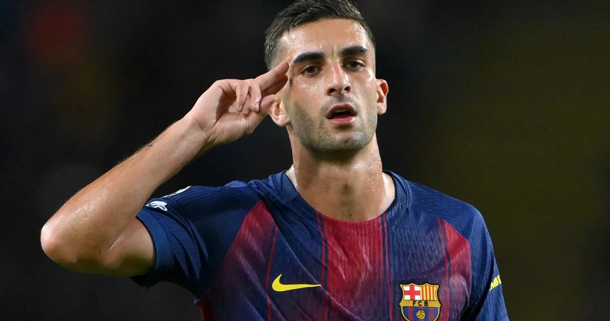 Player celebrating with a salute gesture on pitch
