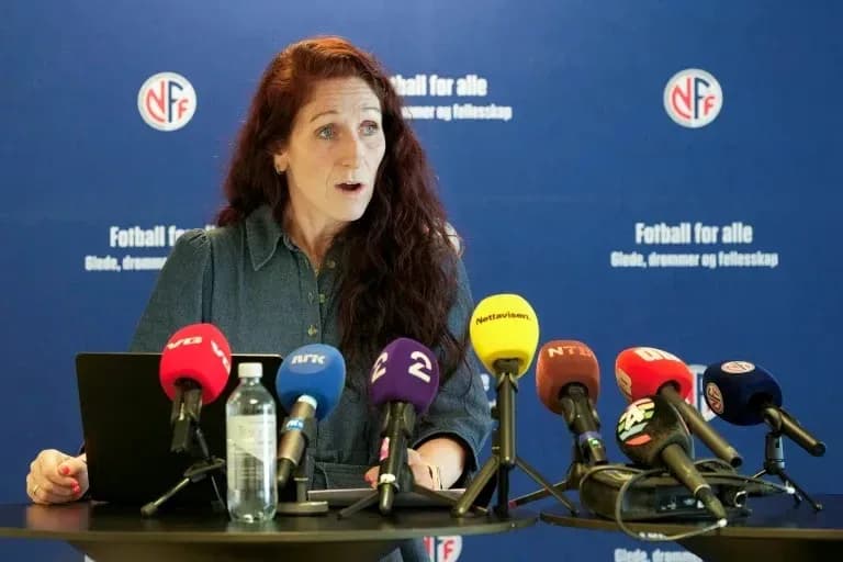 Speaker at press conference with multiple microphones
