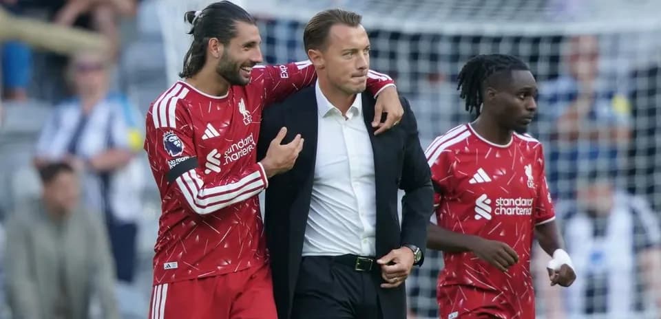 Liverpool players celebrating with their manager on pitch