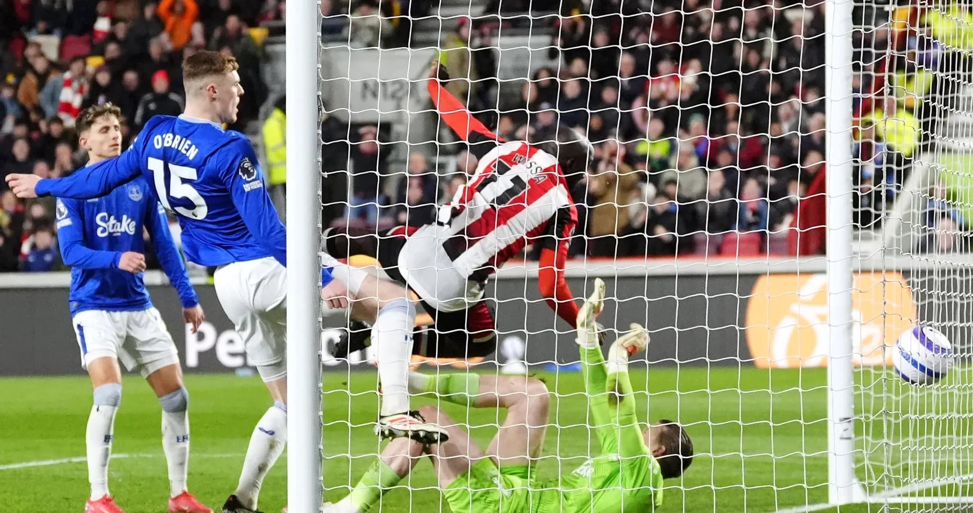 Brentford player scoring against Everton goalkeeper