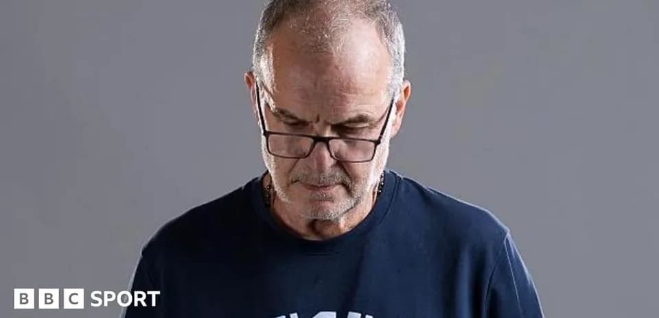 Man wearing glasses looking down with gray background