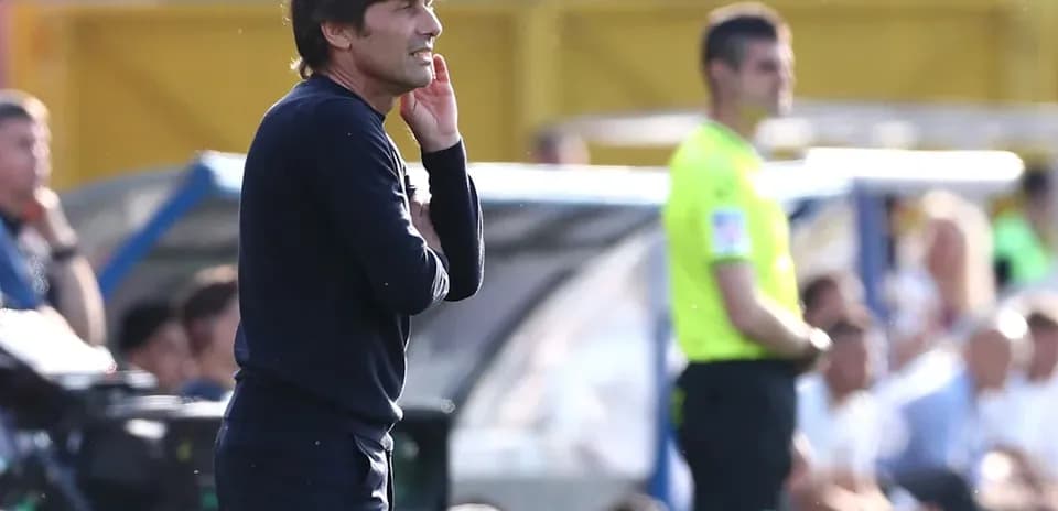 Coach gesturing during match with referee nearby