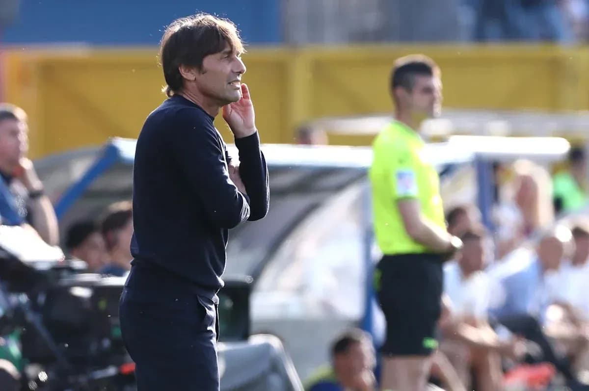 Coach gesturing during match with referee nearby