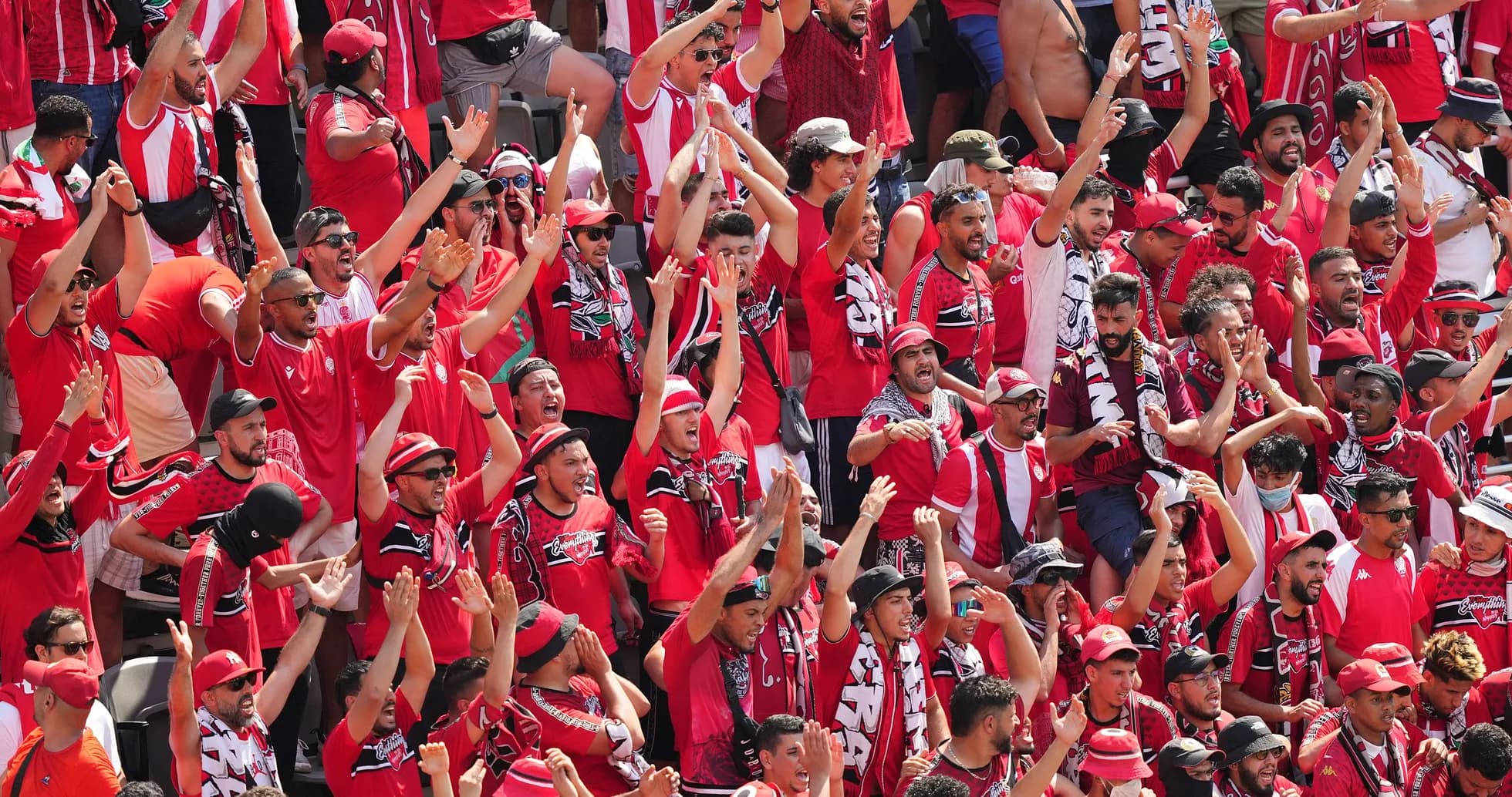 Fans in red cheering at a sports event
