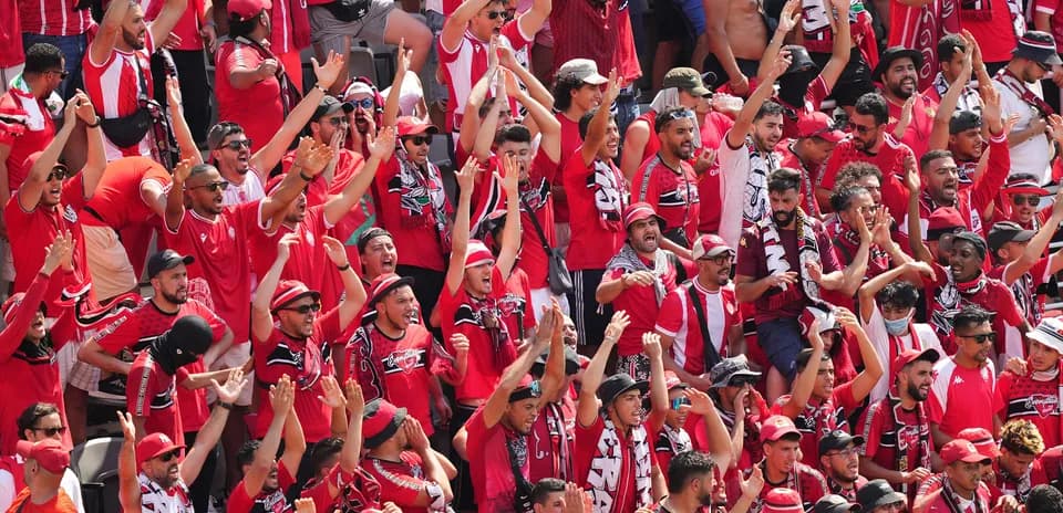Fans in red cheering at a sports event