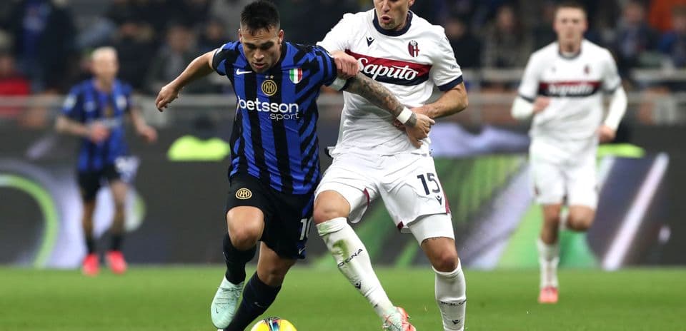Bologna player challenges Inter player for the ball