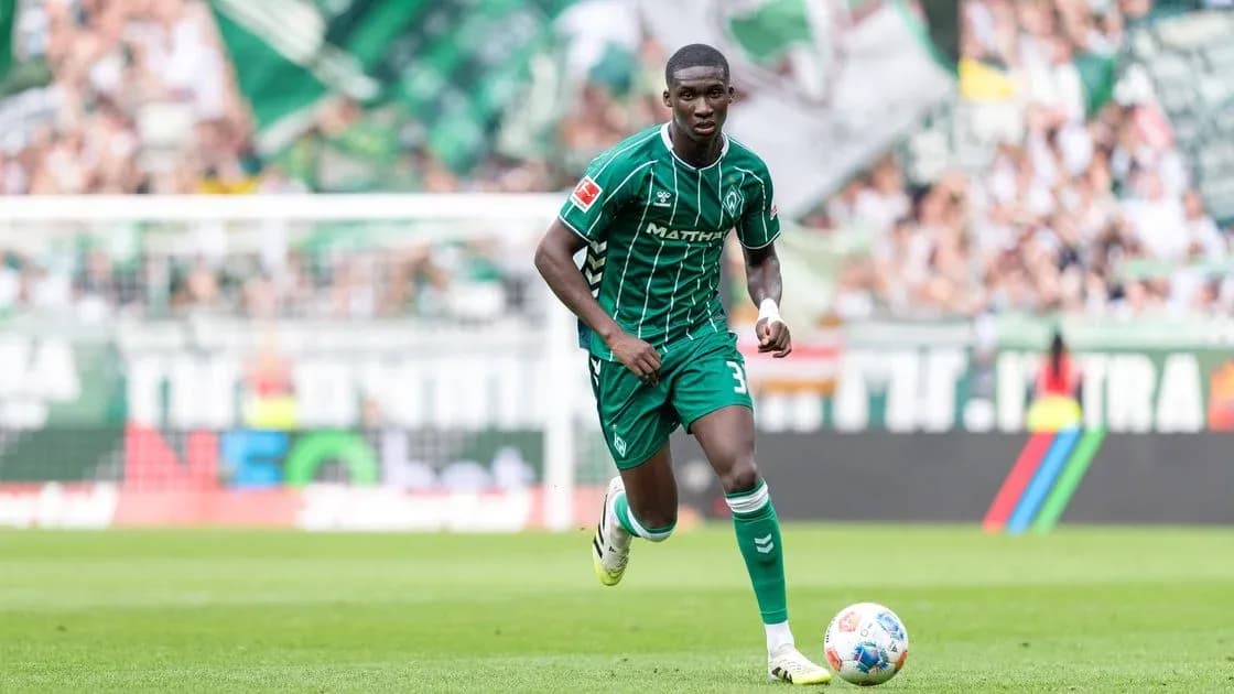 Player in green kit running on the field
