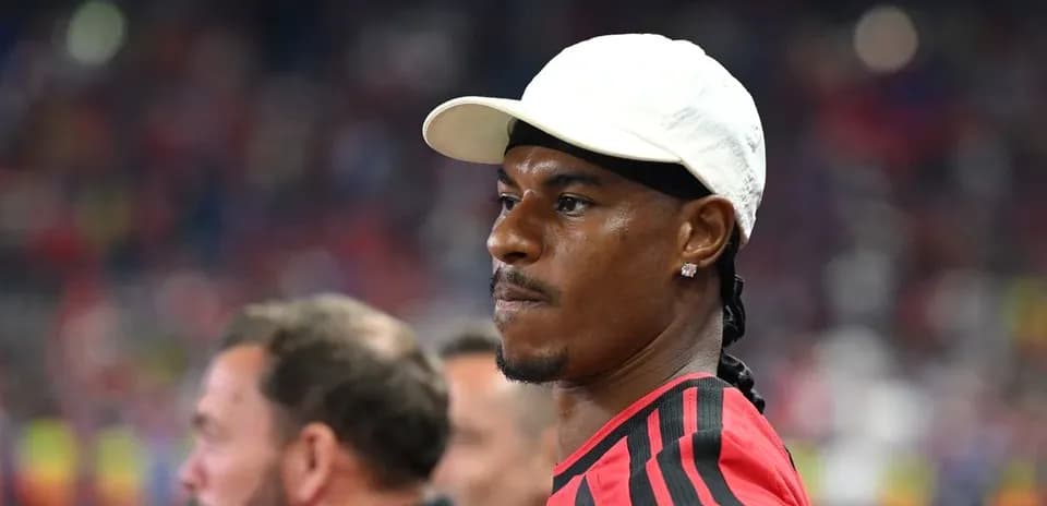 Player wearing a white cap on sidelines