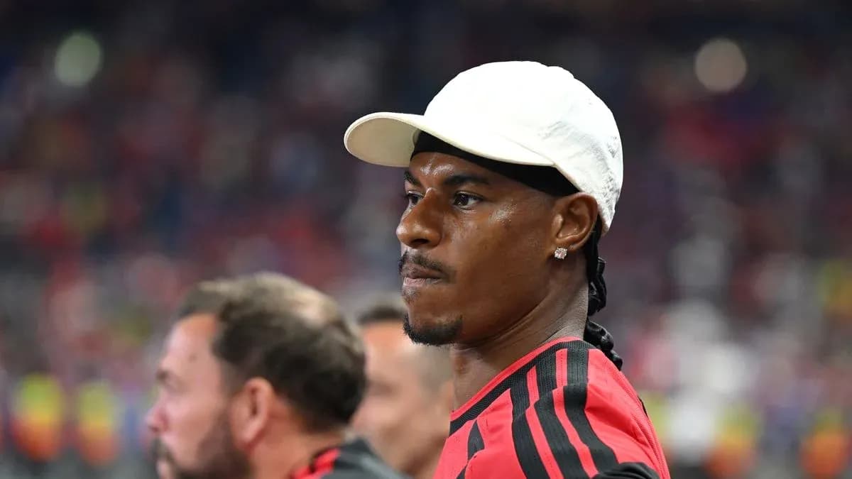 Player wearing a white cap on sidelines