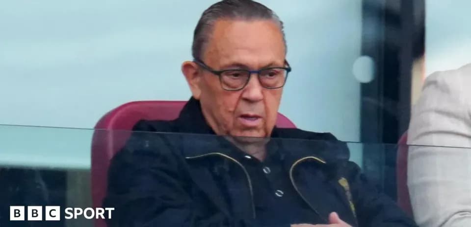 Man in glasses watching match from VIP box