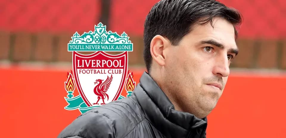 Man in black jacket near Liverpool FC logo