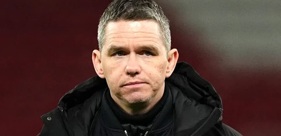 Football manager in a black jacket on the field